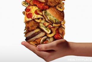 A hand holding a large stack of food